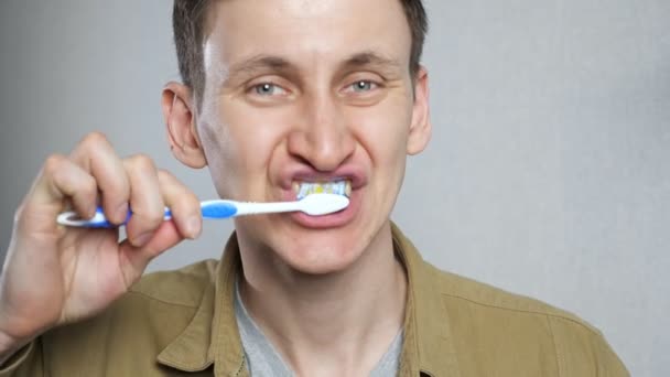 Primer plano disparo joven hombre cepillarse los dientes en el baño. — Vídeos de Stock
