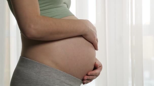 Schwangere in Sportbekleidung streichelt großen nackten Bauch — Stockvideo