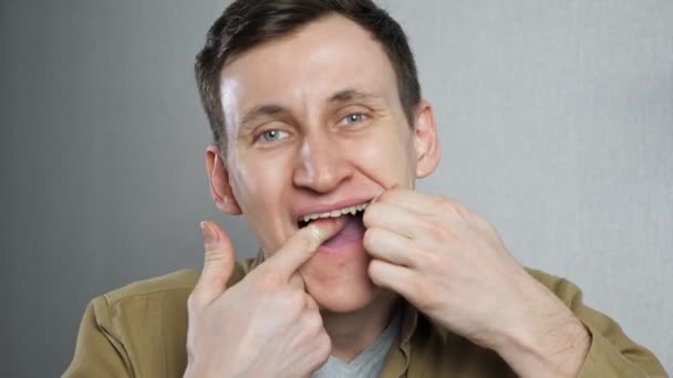 Közelkép a fiatal férfi fogselyem fogselyem — Stock videók