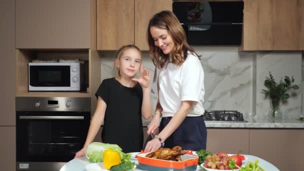 Moeder en tiener dochter veel plezier met het snijden van groenten thuis — Stockvideo