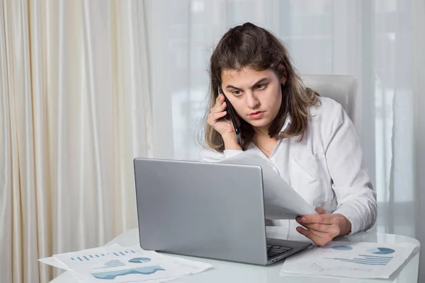 Funktionshindrade kvinna talar i telefon och tittar på projektuppsatsen — Stockfoto