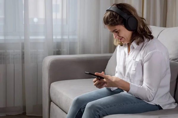 Mujer discapacitada en auriculares escucha música sosteniendo el teléfono — Foto de Stock