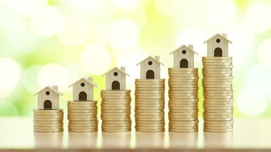 Bozuk para yığını üzerinde mini ev. 3D konsept oluşturma için para biriktiriliyor.
