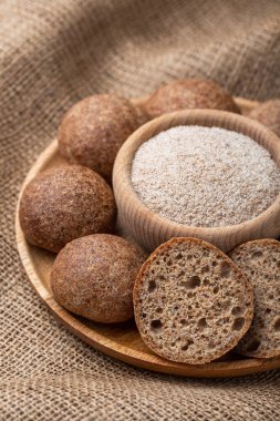 Psyllium ve tohumlarla pişirilmiş düşük karbonhidratlı çörekler. Tahta bir tabakta psilyum. Keto diyeti. Sağlıklı gıda konsepti