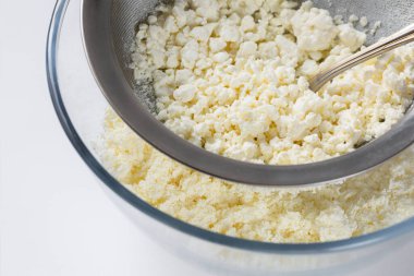 Rubbing cottage cheese through a sieve. manual way.