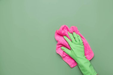 Üzerinde mikrofiber bez olan lastik koruyucu eldiven giymiş bir işçi eli yüzeyi siliyor. Bahar genel veya düzenli temizlik. Saflık kavramı