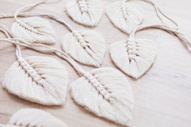 Tahta arka planda doğal renklerde Macrame yaprakları var. Evinizi daha samimi ve eşsiz yapmak için pamuk ip makrome. Kadın hobisi. 