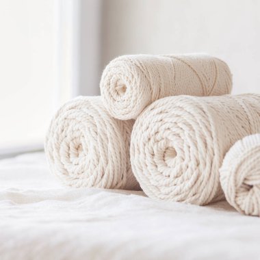 Beyaz arka planda el yapımı makrome örgü ve pamuk iplikleri. Makrome ve el sanatları afişleri ve reklamlar için hafif görüntü iyi. Boşluğu kopyala