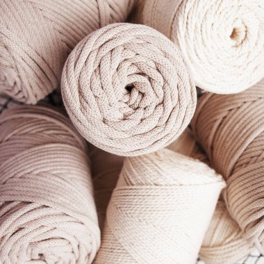 Beyaz arka planda el yapımı makrome örgü ve pamuk iplikler. Pamuk makrome kablolar ve tel sepetteki ipler. Kapat.