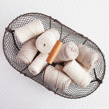 Beyaz arka planda el yapımı makrome örgü ve pamuk iplikler. Makrome ve el sanatları afişleri ve reklam için iyi bir görüntü. Uzayı kopyala Üst görünüm