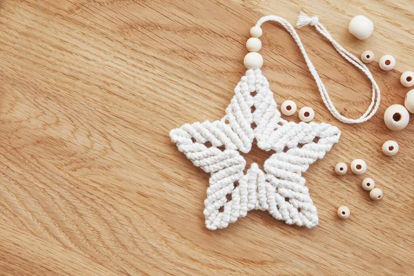 Macrame Leaf in Natural Color on a Wooden Table. Cotton Rope Decor