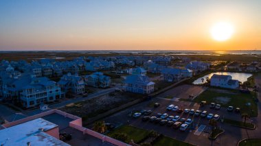 Aerial drone view of paradise island with new development real estate homes and condos along the beach with waves crashing into the horizon near Corpus Christi Texas