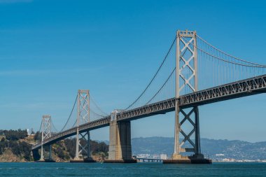Oakland 'dan San Francisco Körfez Köprüsü' ne kadar olan uzun altyapı planı güneşli bir öğleden sonra Kaliforniya, San Francisco sahilinde büyük bir asma köprü ile Bay Area 'yı geçiyor.
