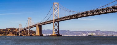 Oakland 'dan San Francisco Körfez Köprüsü' ne kadar olan uzun altyapı planı güneşli bir öğleden sonra Kaliforniya, San Francisco sahilinde büyük bir asma köprü ile Bay Area 'yı geçiyor.