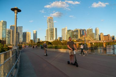 Austin, TX, ABD - 21 Ekim 2020: Austin Texas 'ın merkezindeki Sunset' teki Skyline Cityscape 'te zombiler ve bisikletçilerle Kasaba Pedestrian Köprüsü' nün tadını çıkarmak