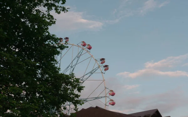 LAZAREVSKOE, SOCHI, RUSIA - 26 de mayo de 2021: Rueda de la fortuna contra el cielo del atardecer. Sobre la rueda la inscripción Lazarevskoe. — Foto de Stock