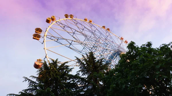 LAZAREVSKOE, SOCHI, RUSIA - 26 de mayo de 2021: Rueda de la fortuna contra el cielo del atardecer. Sobre la rueda la inscripción Lazarevskoe. — Foto de Stock