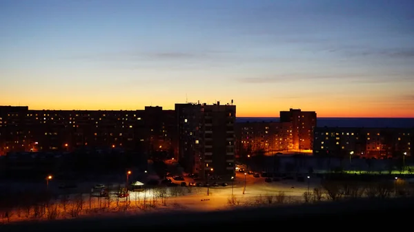 SEVERODVINSK, RUSSIA - MARCH, 11, 2021: Bright winter sunset against the background of houses. Multi-story houses in the rays of the sun. The sun goes down behind the houses. — Stock Photo, Image