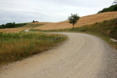 Tuscany, İtalya 'daki tipik tozlu yollar. Çevresi güzel, manzarası güzel ve eski evleri var..