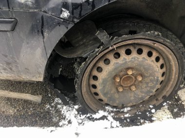 Terk edilmiş aracın lastiği patlak, paslı tekerleğin ayrıntıları. Lastik tamamen kırılmış ve lastik izi ayrılmış..