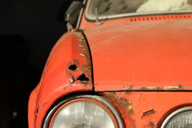 İhmal edilmiş klasik bir arabanın ön kısmının ayrıntıları. Metal kaput ve çamurluk paslanmış ve yenilenmesi gerekiyor.. 