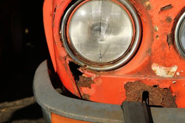 İhmal edilmiş klasik bir arabanın ön kısmının ayrıntıları. Metal kaput ve çamurluk paslanmış ve yenilenmesi gerekiyor.. 