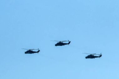Üç Sovyet savaş helikopteri, MIL Mi-24 tipi mavi gökyüzünde uçuyor..