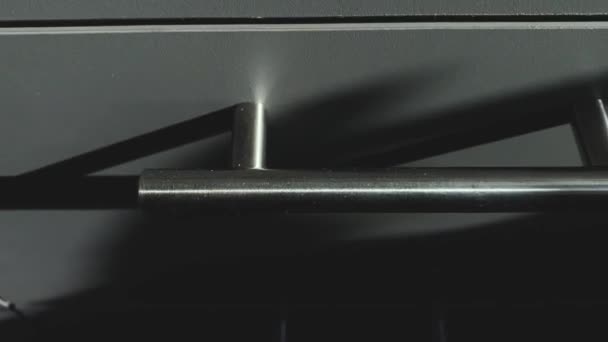 Detailní záběr s detaily kuchyňských skříněk, šedých barev.
