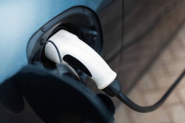 Elektrikli araca şarj gücü için güç kablosunun fişini yaklaştır.