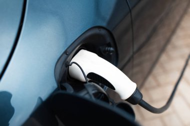 İstasyonda elektrikli bir araba şarj oluyor. Eklentinin yakın görüntüsü.