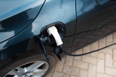 Elektrikli arabanın fişini şarj istasyonuna takın. Kapsülün üst görüntüsü.
