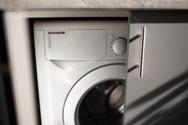 Mutfak gri dolabının içindeki çamaşır makinesinin yakın çekimi..