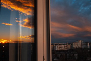 Gün batımında güzel bulutlu gökyüzünün pencere yansıması.