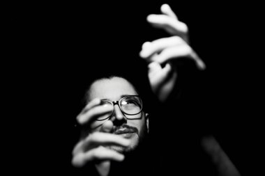 Siyah-beyaz, genç adamın siyah portresi, ışığa bakıyor..