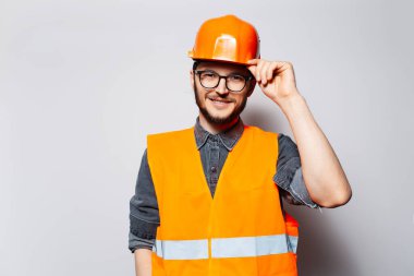 Kendine güvenen genç inşaat işçisinin stüdyo portresi.