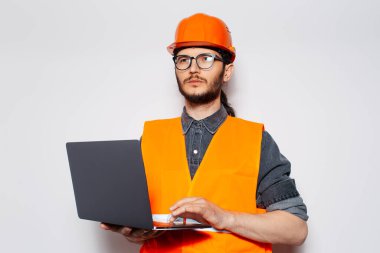 Bilgisayarı beyaz arka planda olan ciddi bir inşaat mühendisi..