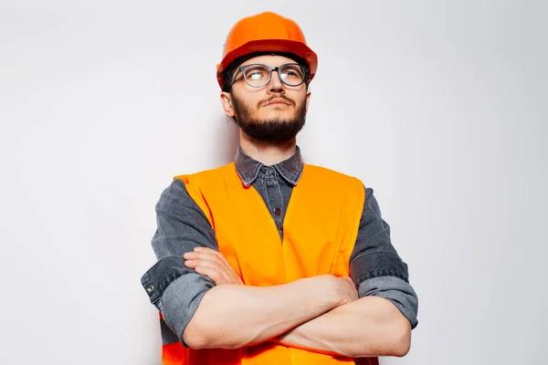 白い背景に交差腕を持つ若い建設労働者の肖像画 — ストック写真