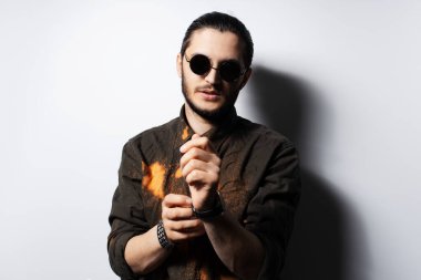 Genç bir adamın portresi beyaz arka planda saatinin kayışını ayarlıyor..