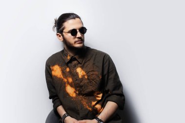 Beyaz arka planda kendinden emin genç bir adamın portresi..