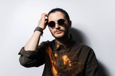 Beyaz arka planda genç ciddi bir adamın stüdyo portresi.