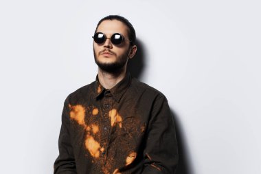 Beyaz arka planda genç bir adamın stüdyo portresi.