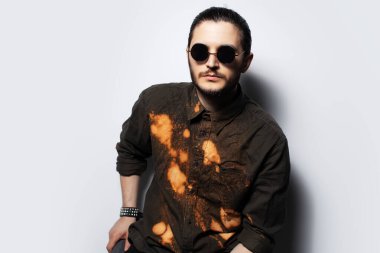 Beyaz arka planda kendine güvenen genç bir adamın stüdyo portresi.