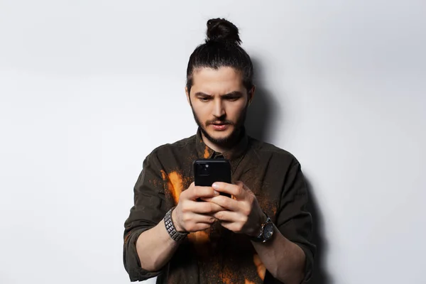 Πορτρέτο Του Νεαρού Άνδρα Κουλούρι Μαλλιών Ψάχνει Στο Smartphone Λευκό — Φωτογραφία Αρχείου