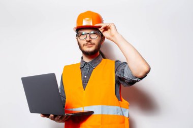 Beyaz arka planda dizüstü bilgisayarı tutan genç mühendisin portresi..