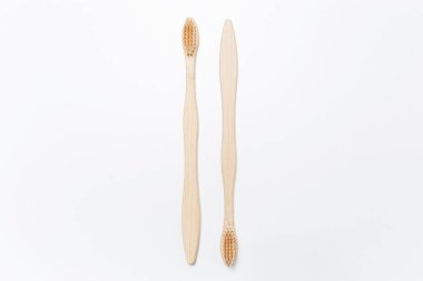 Beyaz arka planda izole edilmiş iki bambu diş fırçası yakın plan..