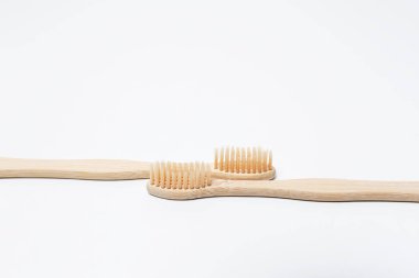 Close-up of two bamboo eco toothbrushes isolated on white background.