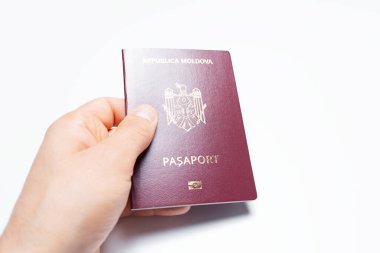 Moldova pasaportu beyaz üzerine kırmızı erkek elinin yakın plan fotoğrafı..