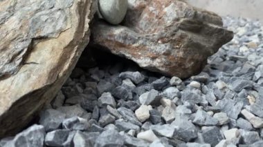 Küçük gri taşların arka planındaki büyük taşların yavaş çekimde yakın plan görüntüsü.