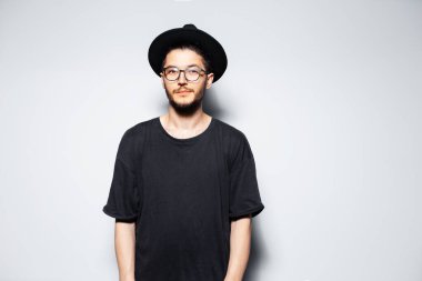 Siyah şapkalı ve gözlüklü çekici bir adamın stüdyo portresi..