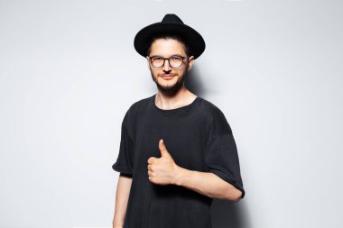 Siyah şapkalı, kendinden emin bir gencin stüdyo portresi..